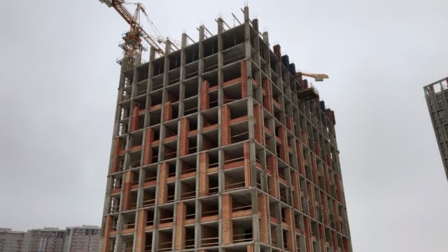 Construction-of-a-high-rise-apartment-house.-The-construction-crane-works-at-the-construction-site