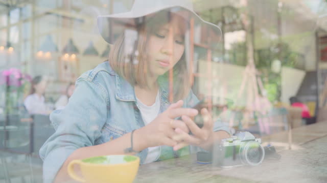 Negocio-freelance-mujer-asiática-con-smartphone-para-hablar,-leer-y-enviar-mensajes-de-texto-mientras-está-sentado-en-la-mesa-de-café.-Estilo-de-vida-elegante-mujeres-hermosas-trabajando-en-conceptos-de-cafetería.