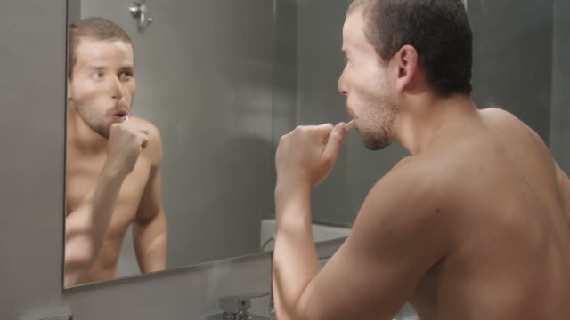 Metrosexual-homosexueller-Mann-Zähneputzen-im-Hotelbad-für-Hygiene