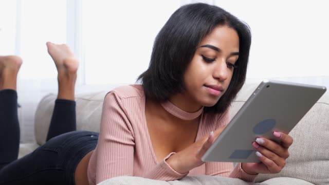 Teenager-Mädchen-mit-digital-Tablette-auf-sofa