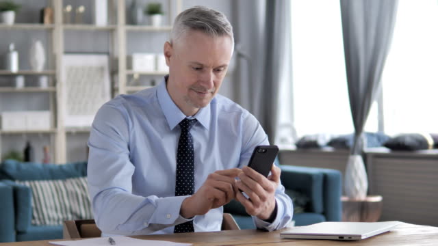 Gray-Hair-Businessman-Using-Smartphone