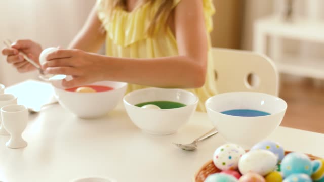 girl-coloring-easter-eggs-by-liquid-dye-at-home