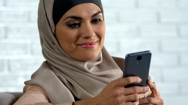 Attraktive-Arab-Frau-scrollt-soziale-Netzwerke-auf-Smartphone,-moderne-Technik