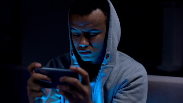 Unglücklicher-afrikanischer-Teenager-Prorastinator-verliert-Videospiel-auf-Smartphone