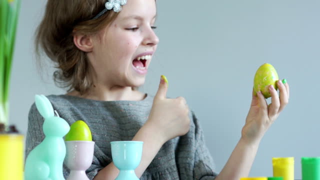 Girl-paints-Easter-eggs-with-her-fingers