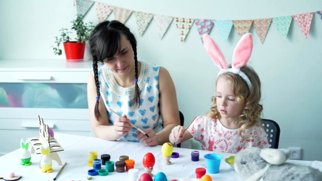 Little-Girl-Decorating-Easter-Egg-with-her-Mother