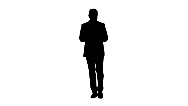 Silhouette-Businessman-swiping-pages-on-a-tablet-and-talking-to-camera-explaining-something-while-walking