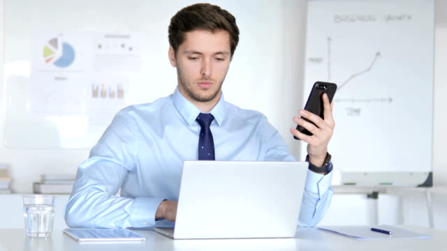Multitasking-Geschäftsmann-mit-Smartphone,-Tablet-und-Laptop-am-Arbeitsplatz