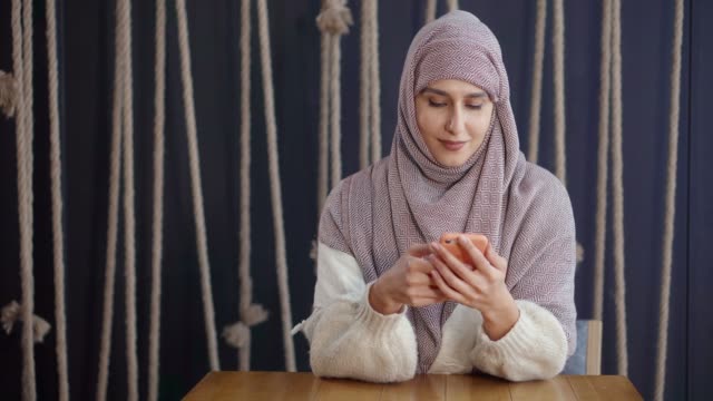 Glückliche-muslimische-Frau-mit-Smartphone