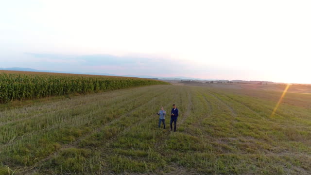 Dos-jóvenes-agricultores-modernos-caminando-sobre-el-campo