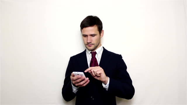 Young-handsome-businessman-is-viewing-a-news-feed-on-his-smartphone.