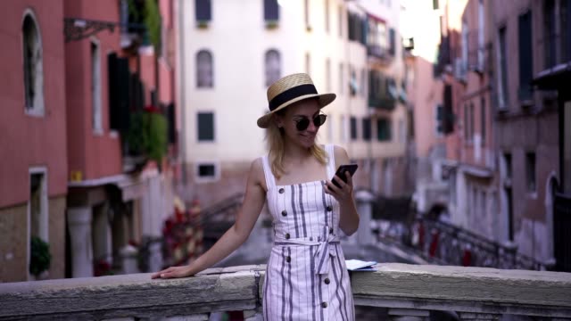 Zeitlupe-von-glücklich-aufgeregt-Hipster-Mädchen-beobachten-lustige-Wirkung-online-über-mobile-Anwendung,-während-auf-italienischen-Brücke-während-der-Ferien-Europa-ruhen