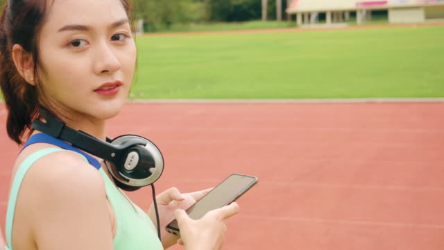 Lifestyle-Asian-sport-women-holding-smart-phone-play-music-relaxation