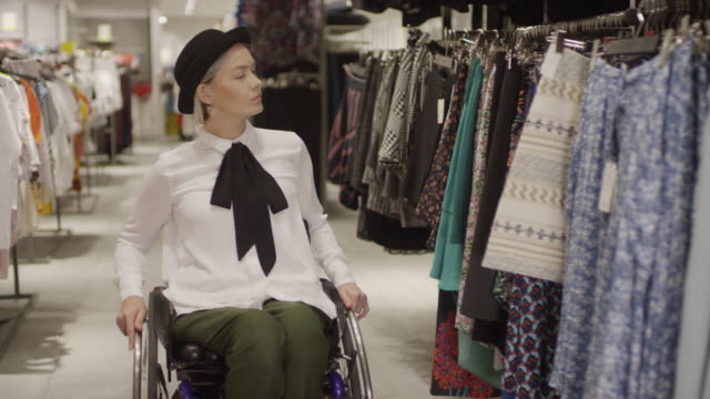 Frau-im-Rollstuhl-Einkaufen-für-Rock-in-Kleidung-Store