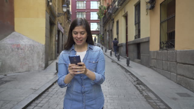 Glückliche-attraktive-junge-Frau-mit-Smartphone-SMS-Nachricht-und-chatten-Anrufe-Freunde,-während-zu-Fuß-auf-der-Stadt-Straße-städtischen-Hintergrund.