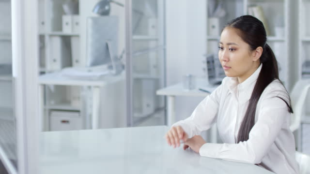 Junge-asiatische-Frau-Blick-auf-unsichtbaren-AR-Touchscreen-im-Büro