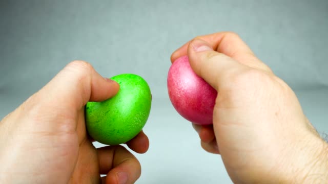 Mann-bereit,-ein-traditionelles-Osterspiel-Eierklopfen-oder-Dumping-Wettbewerb-mit-farbigen-gefärbten-Eiern-während-christlichen-Feiertag-Pascha-oder-Auferstehung-Sonntag-spielen