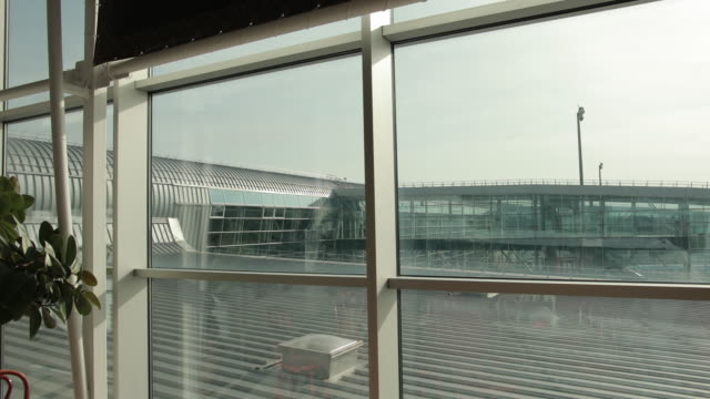 View-on-roof,-floodlight,-bright-sun-from-glass-airport-terminal-window.