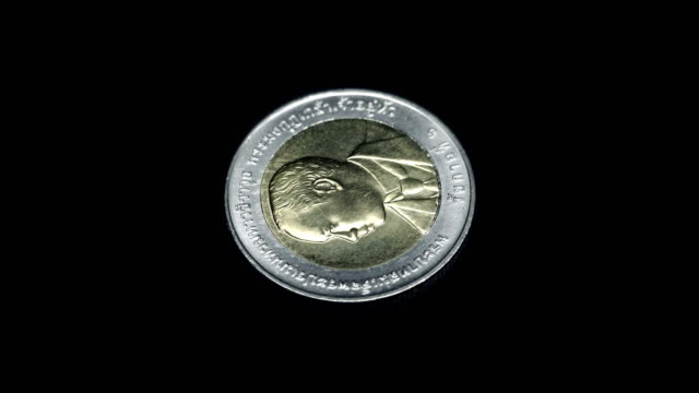 Moneda-conmemorativa-de-Tailandia-(baht)-gira-sobre-un-fondo-negro.-Macro.-Closeup