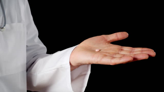 Nahaufnahme-Pille-auf-männliche-Hand-Palme-isoliert-auf-schwarzem-Hintergrund.-Arzt-Hände-halten-Tablet-Medikament-komprimieren-auf-Handflächenhände-auf-dunklem-Hintergrund.
