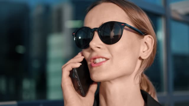 Close-up-face-of-woman-in-sunglasses-communicating-on-telephone.-Shot-on-RED-Raven-4k-Cinema-Camera