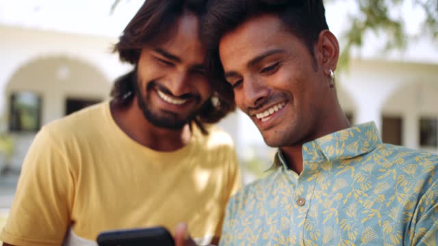 Indische-Freunde-im-Freien-im-Naturpark-mit-Smartphone-Handy