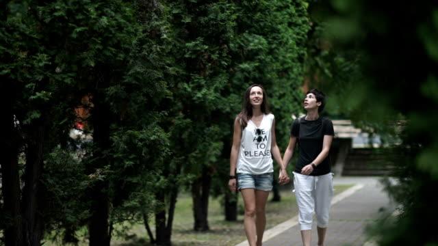 Two-lesbians-holding-hands-and-walking-in-the-park