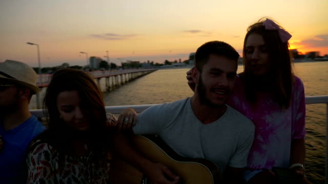 Boys-and-girls-sitting-on-a-bench-and-singing-on-a-pontoon