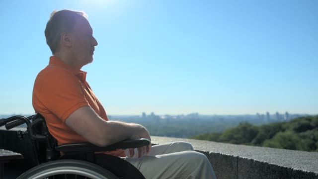 Hombre-wheelchaired-agradable-disfrutando-de-las-vistas-sobre-la-ciudad