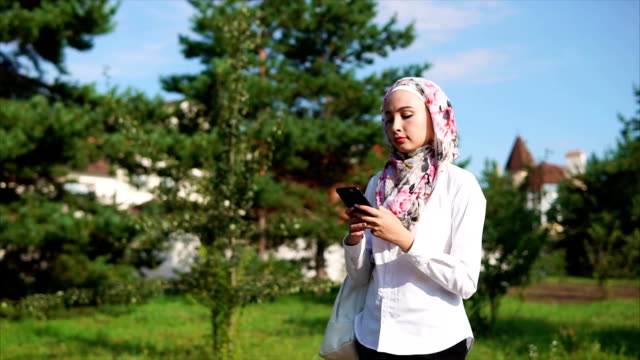 Muslim-girl-using-cell-on-the-go