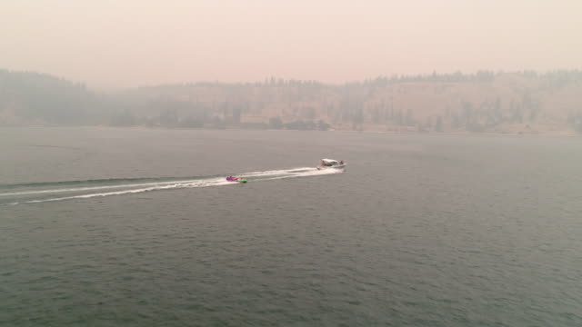 Drone-Flying-Behind-Boat-Towing-Inner-Tubes-in-Eastern-Washington-Wildfire-Haze