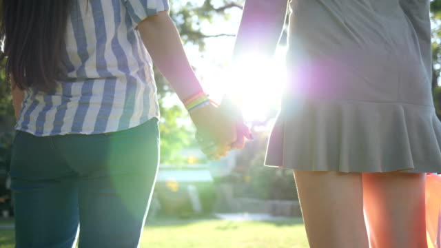 Nahaufnahme-eines-unkenntlich-junge-Frauen-mit-LGBT-Armband-bei-Gegenlicht-stehen-im-park