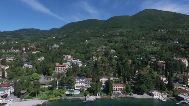 Panorama-del-precioso-lago-de-Garda-rodeado-por-montañas,-Italia.-Video-tiro-con-abejón