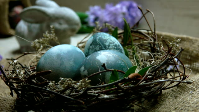 Hyazinthe-Blüte-fällt-auf-das-Osternest-mit-natürlich-gefärbten-Eiern