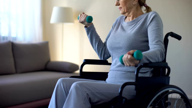 Atlética-abuela-en-silla-de-ruedas-levantar-pesas-en-casa,-guardar-ajuste,-deporte