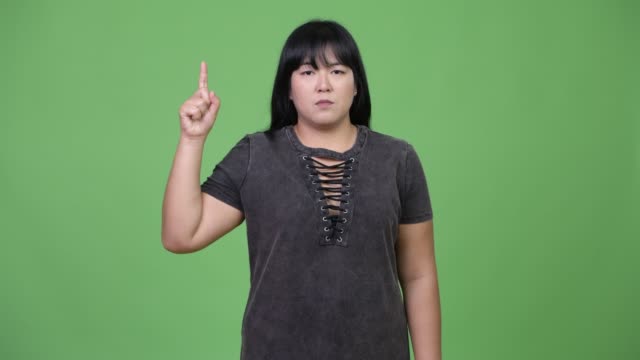 Schöne-Übergewicht-asiatische-Frau-Finger-oben