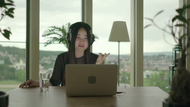 Young-woman-sitting-at-home-working-with-computer-and-chair-dancing