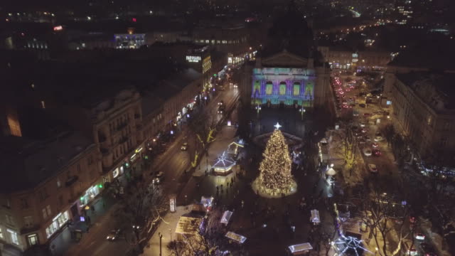 Lviv,-Ukraine.-Arial-shot.-Lvov-Opera-house.-Christmas-tree.-Christmas-Fair.-People-are-walking-around-the-city-center.-Winter-Night-time