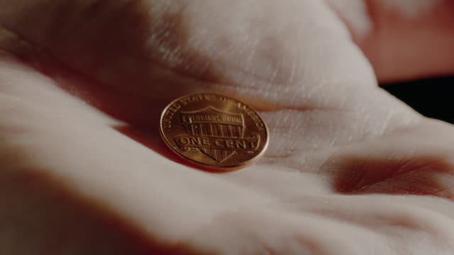 A-hand-opens-revealing-an-extreme-close-up-of-an-American-penny.--At-the-end,-the-hand-then-closes-around-it-for-safe-keeping.