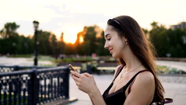 Beautiful-girl-model-look-mobile-phone-closeup-sunset-and-cellphone.-20s-woman