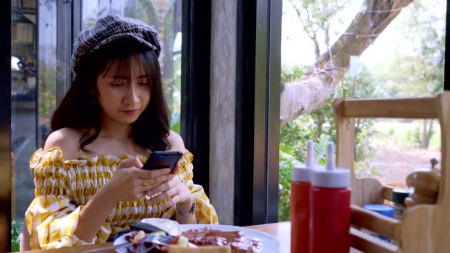 Asiatische-junge-Frau-fotografiert-Frühstück-mit-Smartphone-Social-Media