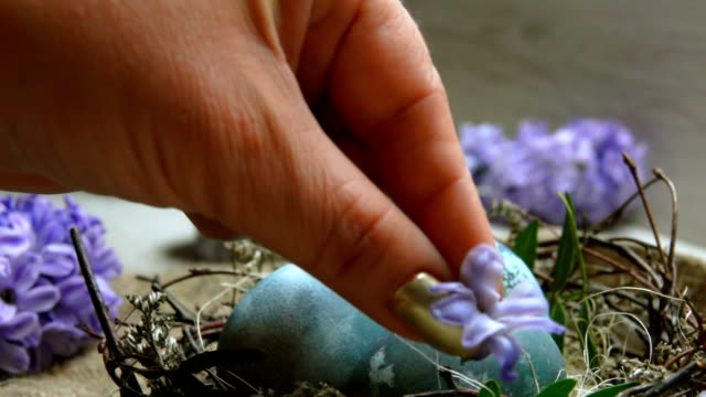 Hands-decorate-Easter-nest-a-hyacinth-flower