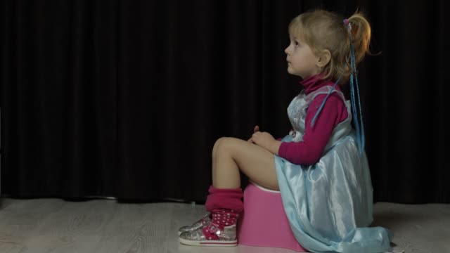 Little-girl-sitting-on-the-potty-and-watching-TV
