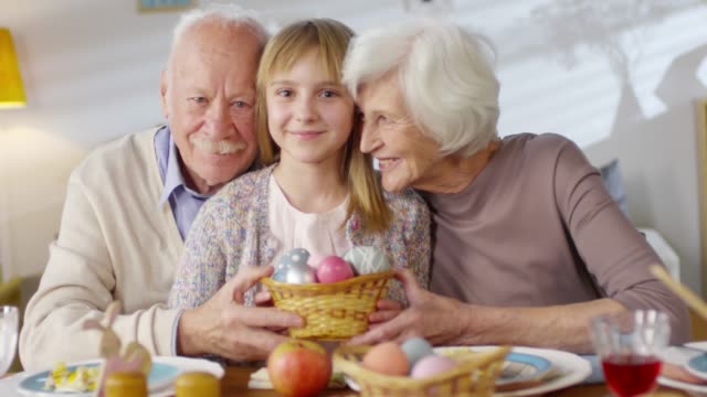 Portrait-of-Grandparents-and-Granddaughter-with-Basket-of-Eggs