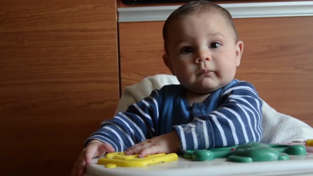Niedlicher-sechsmonatiger-Baby-Junge,-der-mit-künstlichem-Korb-mit-Eiern-spielt-und-ihn-abfällt-Ostereiersuche
