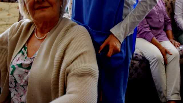 Frontansicht-der-aktiven-Seniorin-hält-Hand-der-Ärztin-im-Pflegeheim-4k