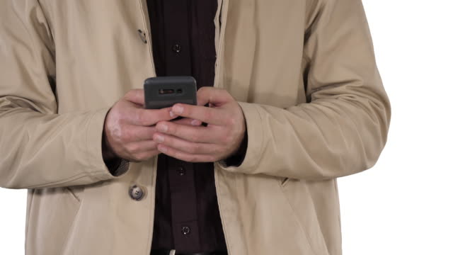 Man-in-trench-coat-using-mobile-smart-phone-on-white-background