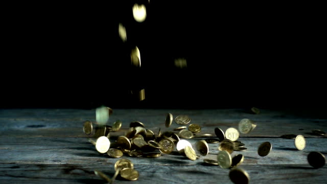 Slow-motion,-a-pile-of-Ukrainian-coins-falls-on-a-wooden
