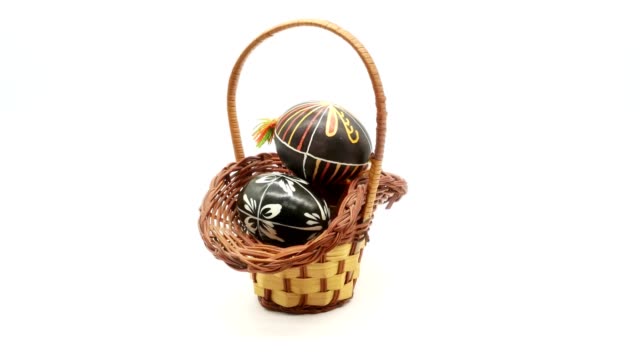 decorative-basket-with-painted-Easter-eggs-on-white-background