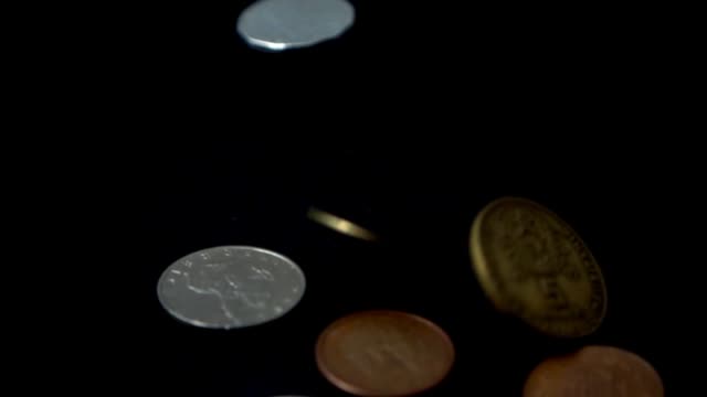 Münzen-fallen-auf-einen-schwarzen-Hintergrund.-zeitlupe.